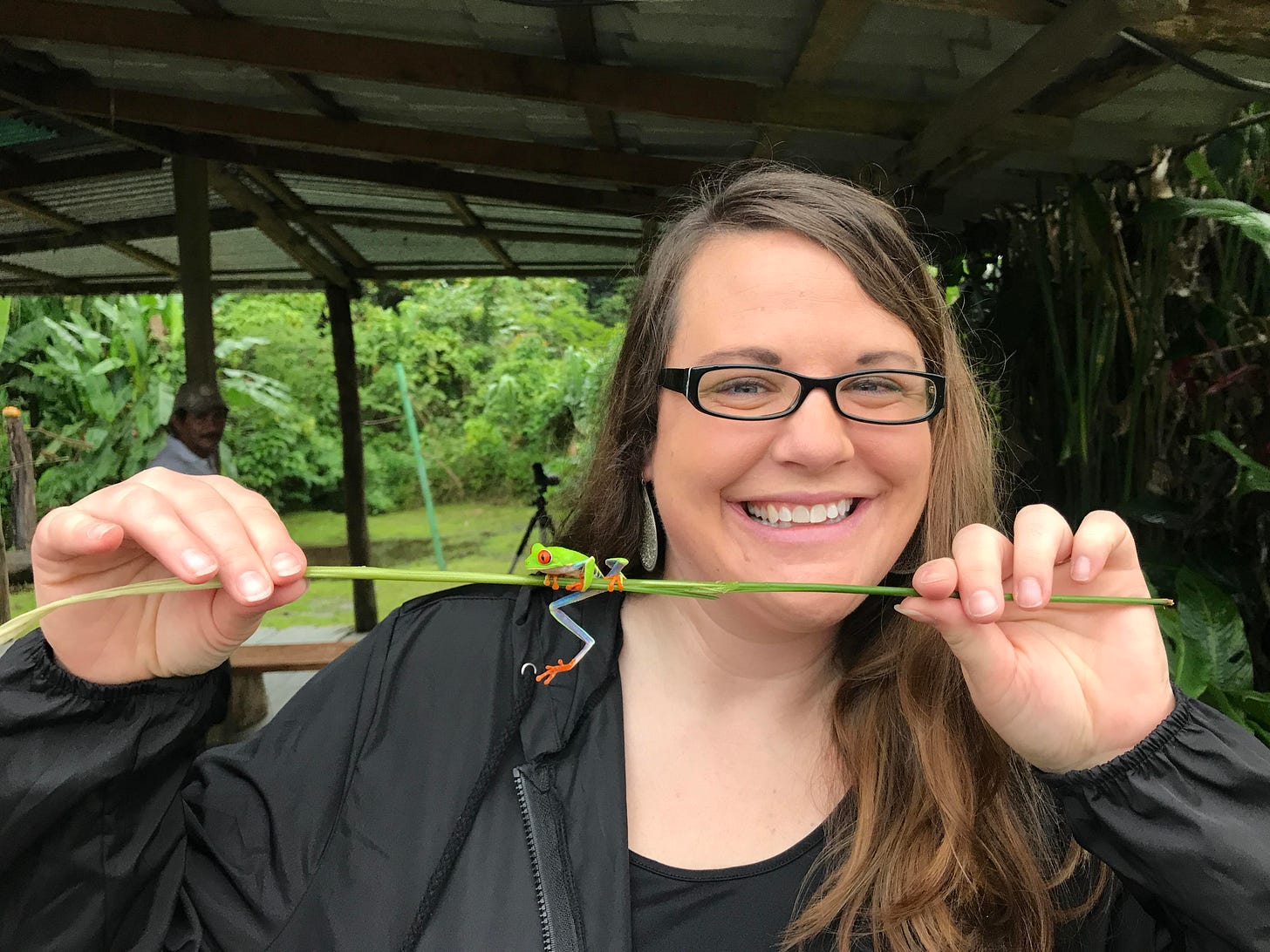 Woman holding stem with Costa Rican national frog sitting on top