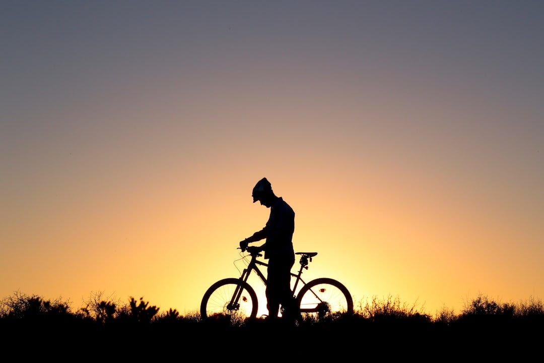 silhouette of man riding bicycle during sunset silhouette of man riding bicycle during sunset