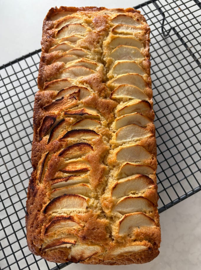 photo of apple loaf cake on black cooling rack.
