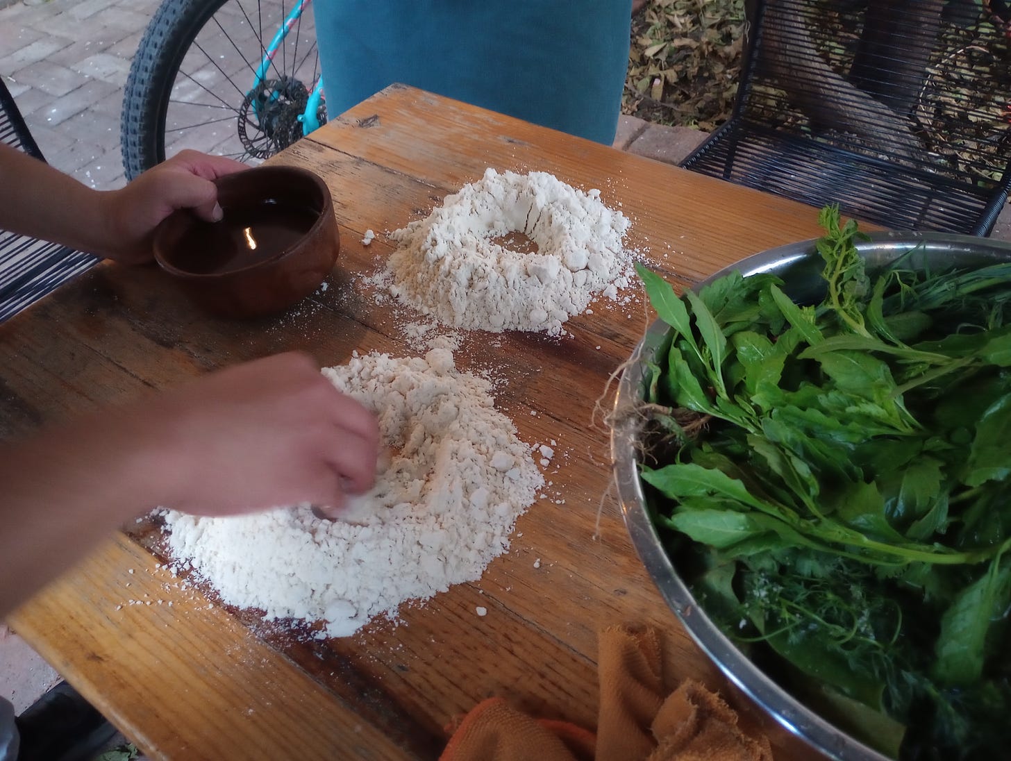 Close-up of hand mixing flours on a kitchen prep table.