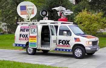 A Fox News van with many logos on it