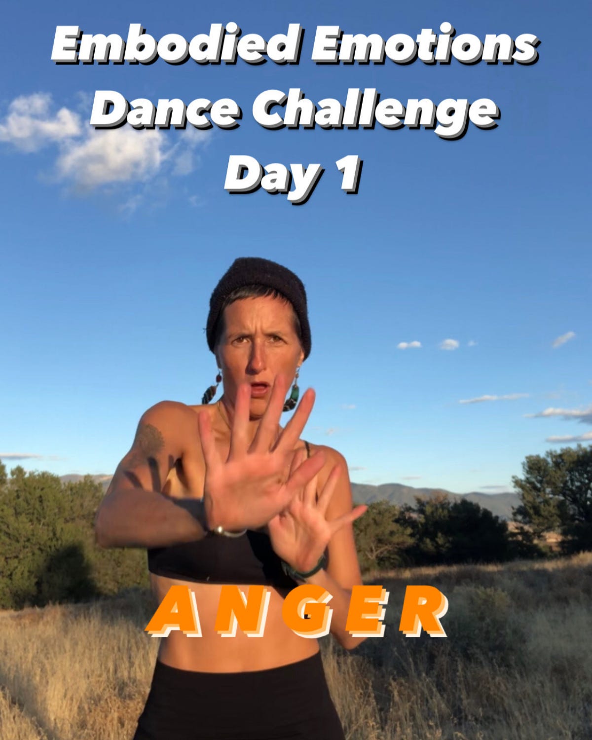 A woman stands in a dry, grassy field with mountains and blue sky behind her, mid-movement with arms extended in an expressive pose. She wears a black sports bra and beanie, embodying the theme of "Anger" for Day 1 of the “Embodied Emotions Dance Challenge,” with bold text framing the image. A woman stands in a dry, grassy field with mountains and blue sky behind her, mid-movement with arms extended in an expressive pose. She wears a black sports bra and beanie, embodying the theme of "Anger" for Day 1 of the “Embodied Emotions Dance Challenge,” with bold text framing the image.