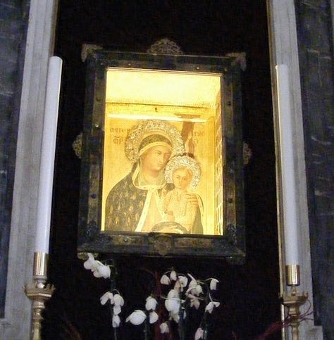 Lake under blue sky, with one mountain in background; icon of Christ and St. Mary; exterior of New Hampshire State House