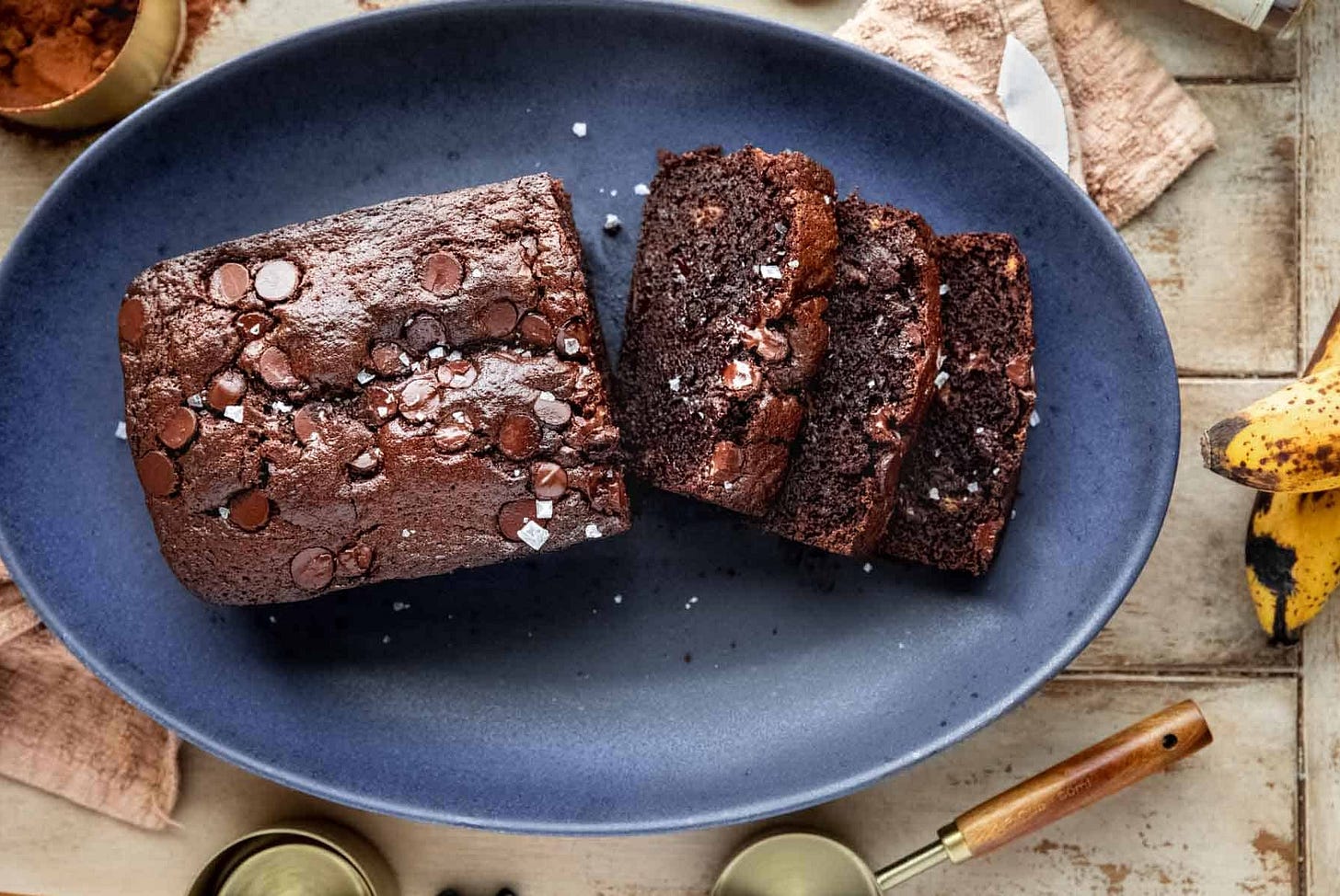 Chocolate Espresso Banana Bread half sliced on a platter. Chocolate Espresso Banana Bread half sliced on a platter.