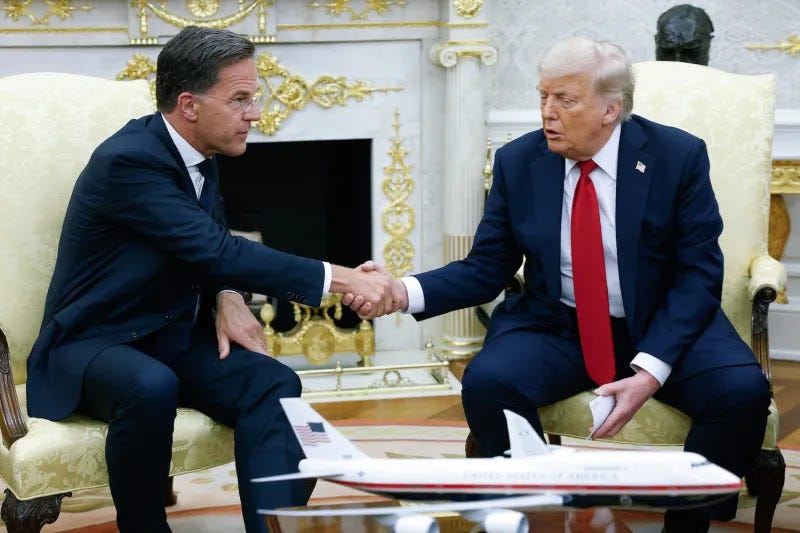 Rutte and Trump shake hands as they sit beside each each other in upholstered chairs in front of an ornate fireplace embellished with gold details. A model of the Air Force One airplane sits on a coffee table in front of them.