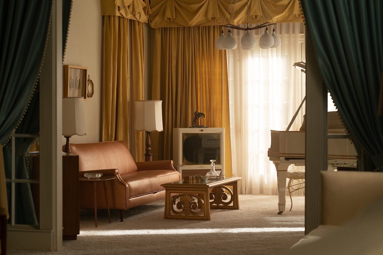downstairs of graceland with tv and piano with gold