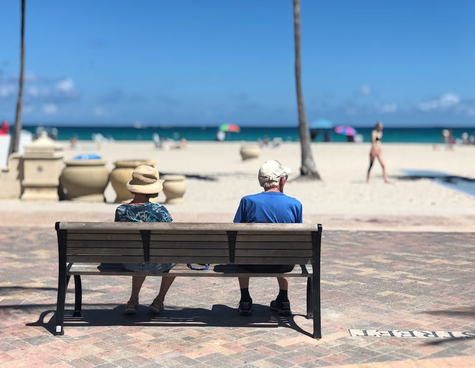 Free Senior couple sitting on a bench enjoying a sunny day at Hollywood Beach, Florida. Stock Photo