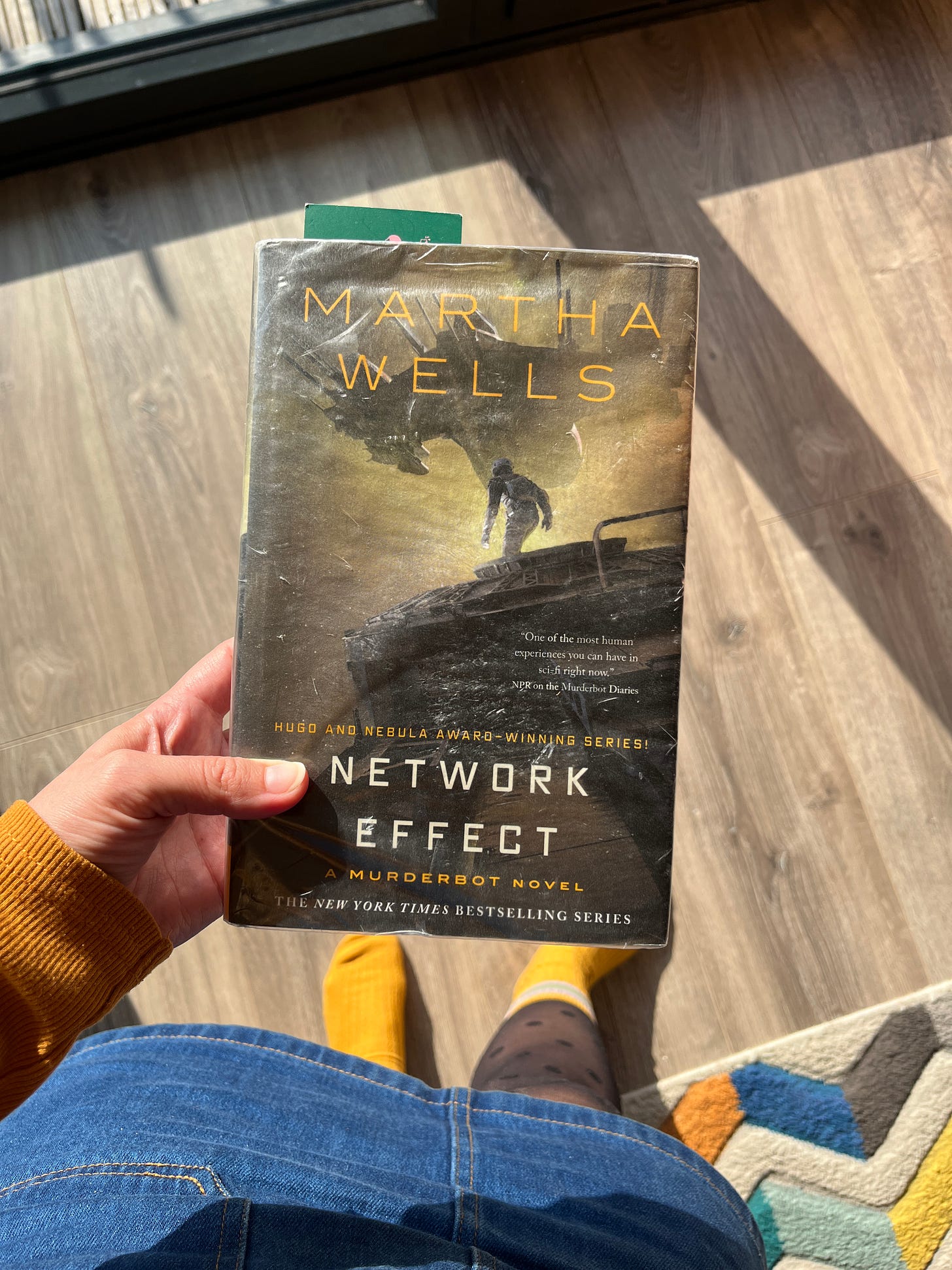 Hannah holding a physical copy of Network Effect 