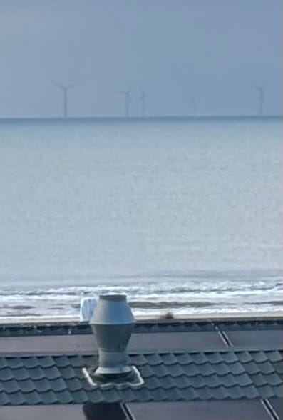 A view of a beach from a building

AI-generated content may be incorrect.