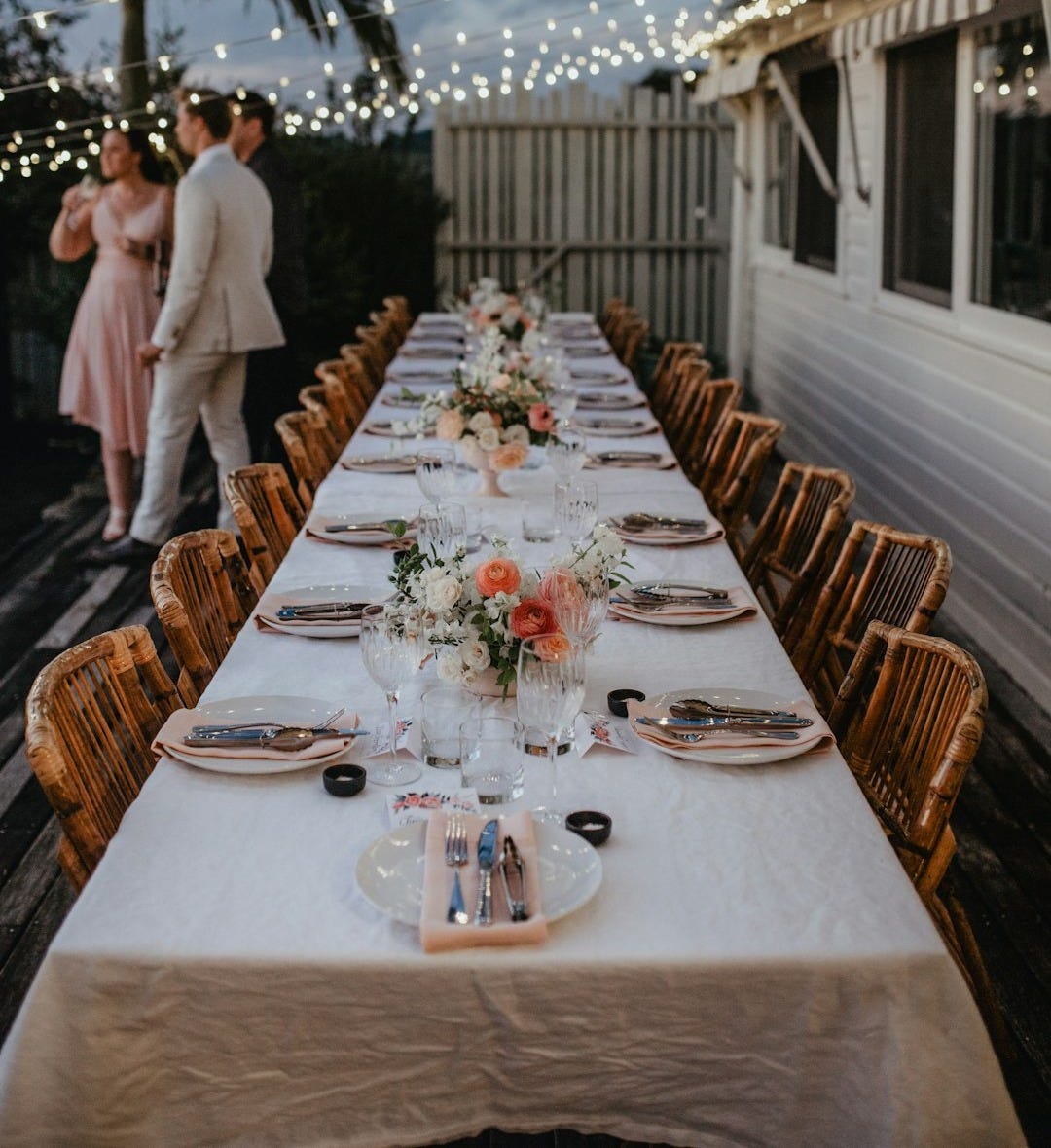 a long table with a couple standing behind it a long table with a couple standing behind it