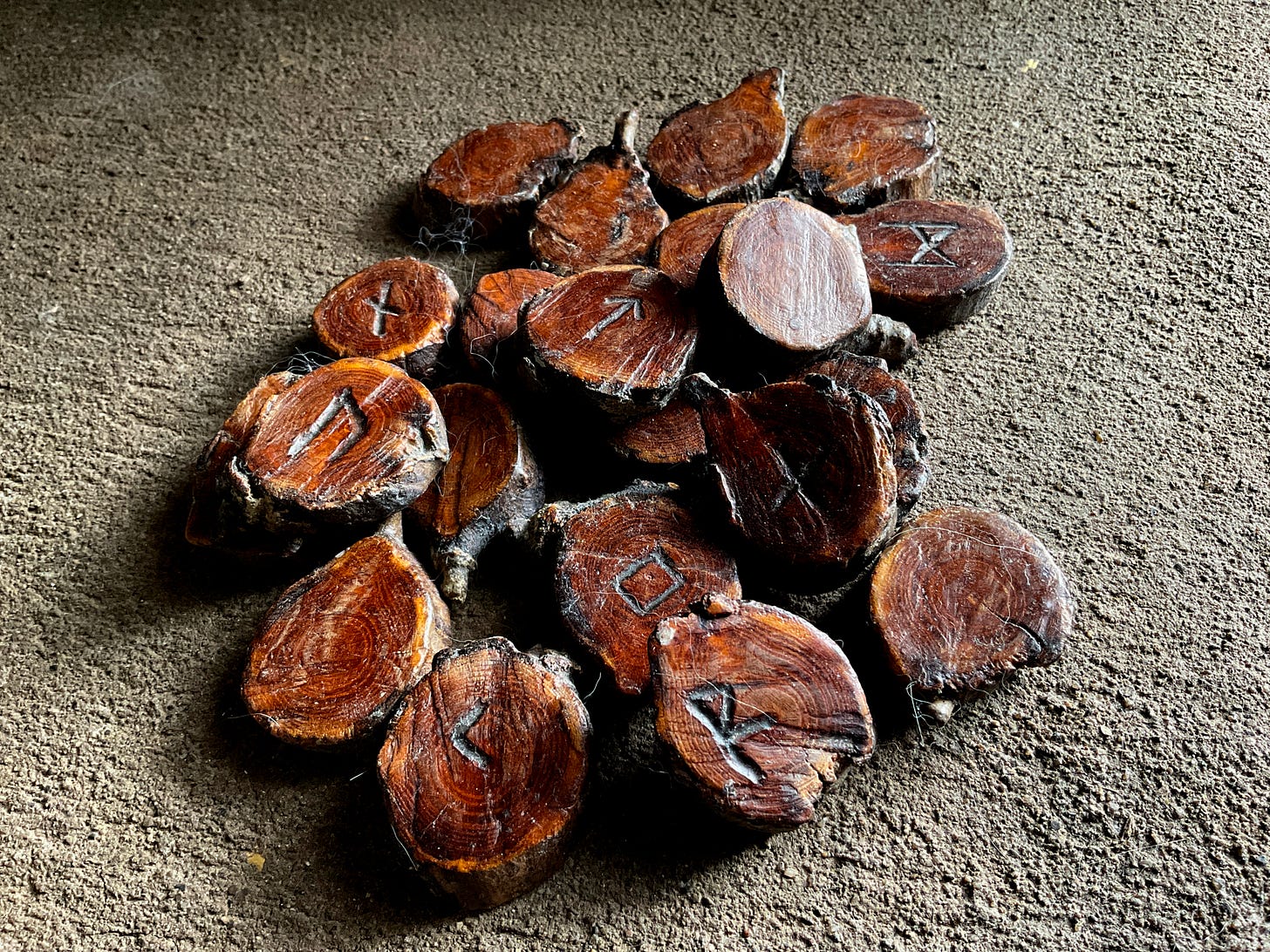 a set of wooden runes, piled, some right side up and some upside down