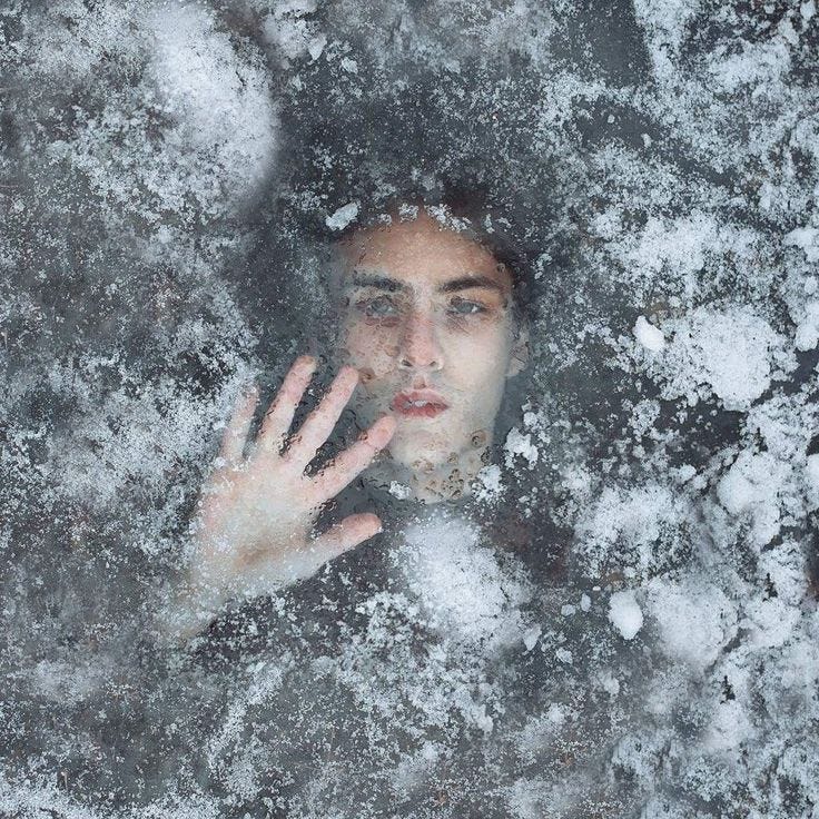 This may contain: a woman is looking through the frosted window with her hand up to her face