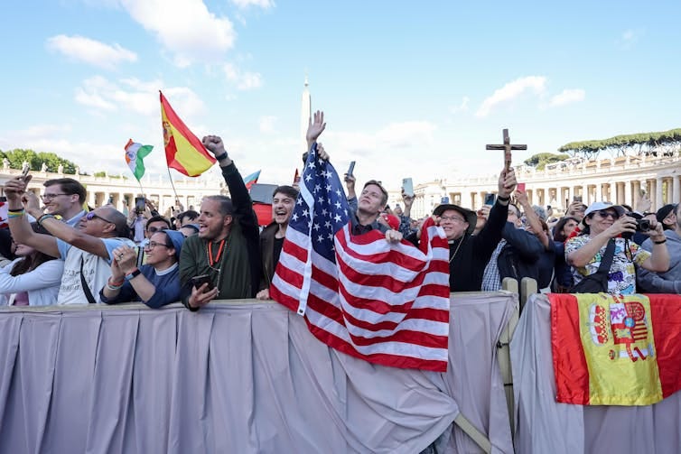 People waving a US flag in St Peter's square, Rome.