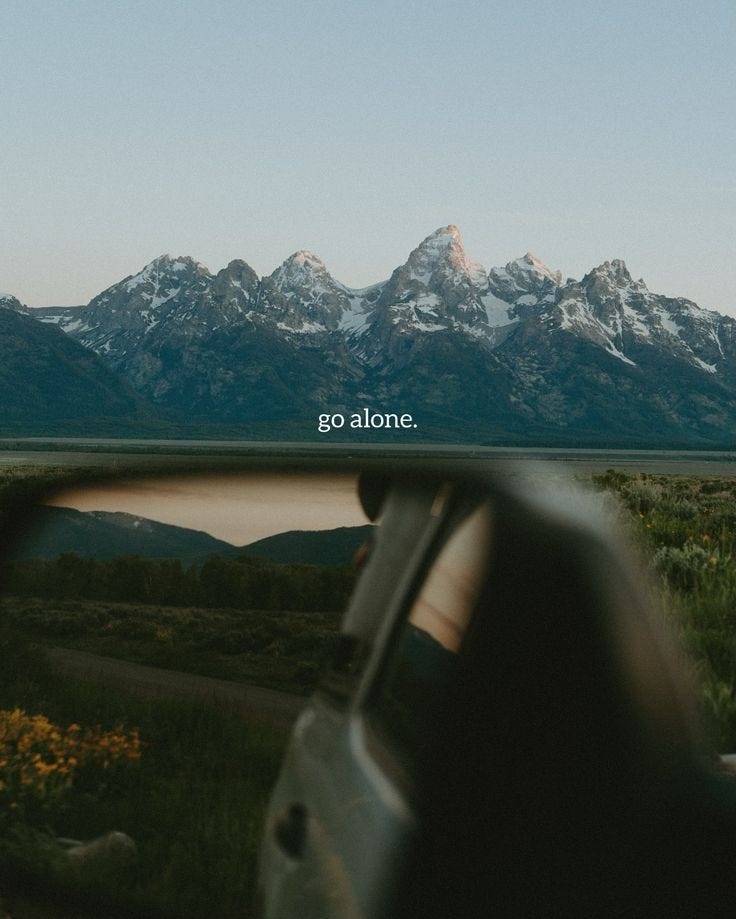 This may contain: a car's side view mirror with the mountains in the background and an ad that reads go alone
