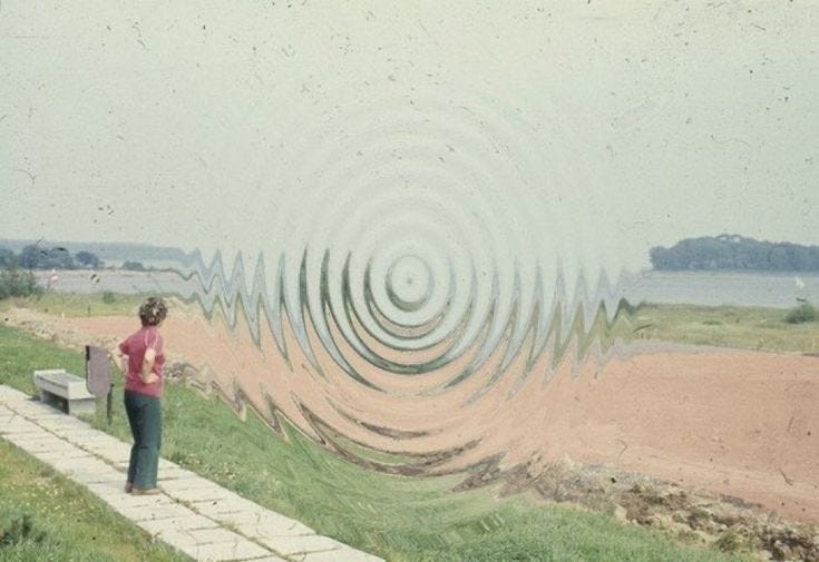 This may contain: a woman standing on a sidewalk next to a body of water with circles in the sky