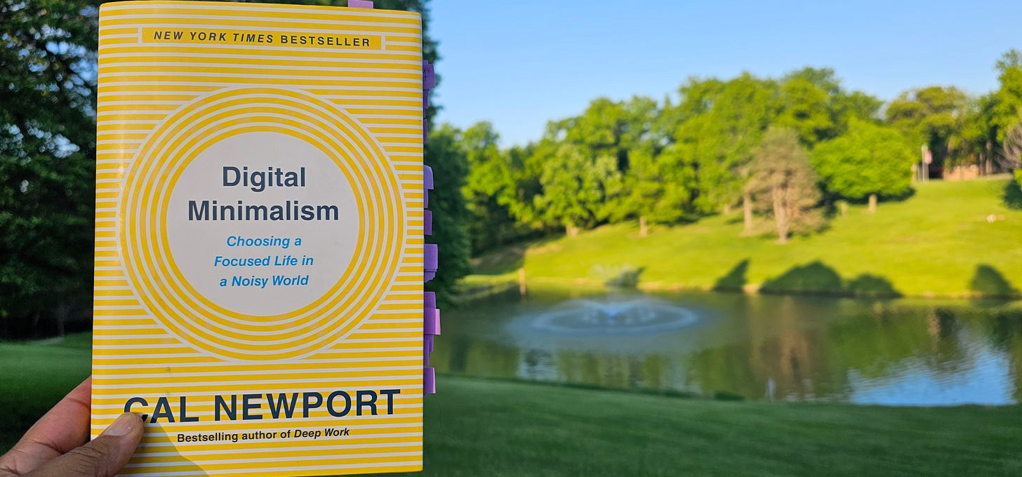 Digital Minimalism book held in front of fountain