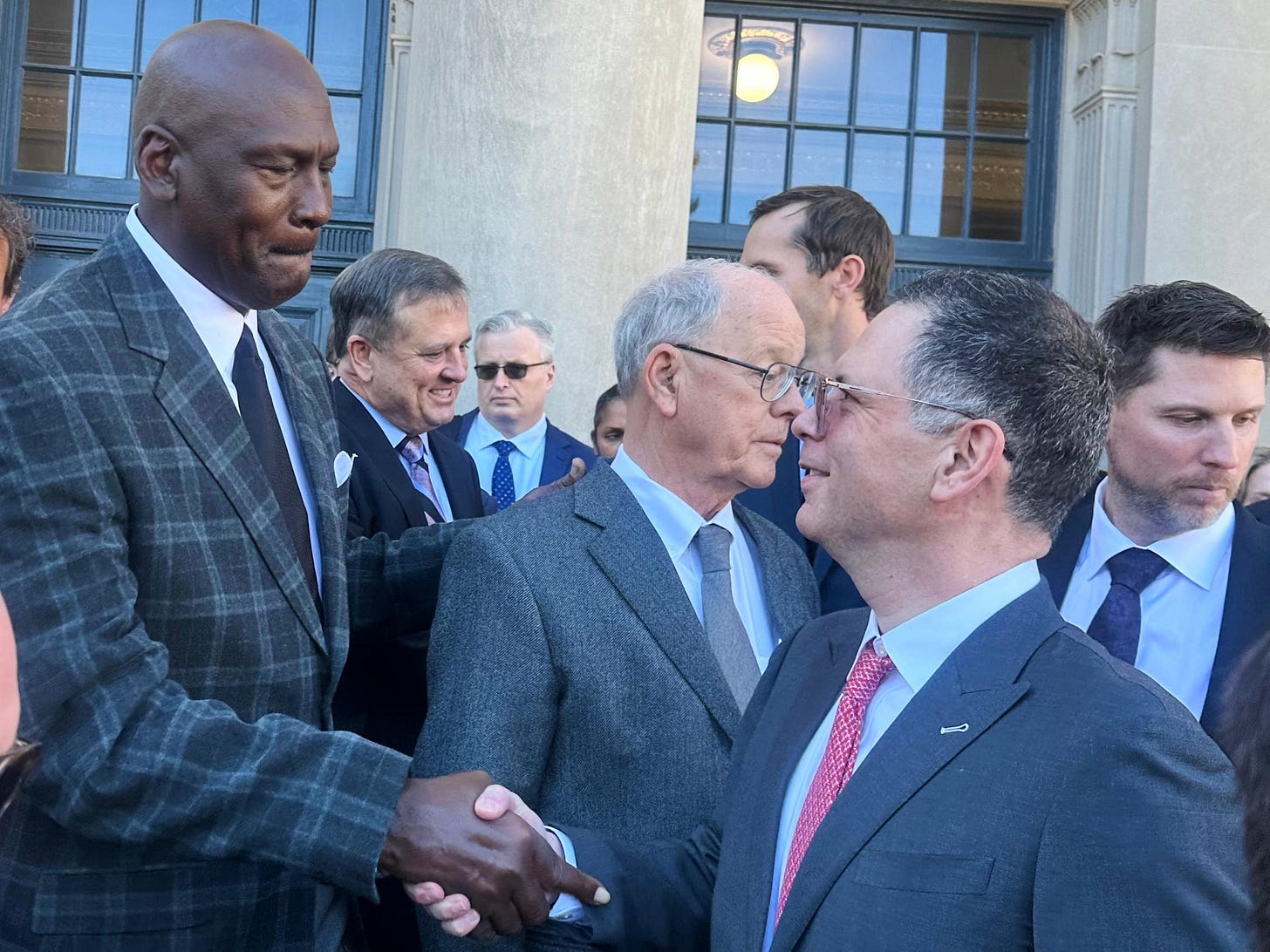 Michael Jordan, left, shakes hands with NASCAR attorney Lawrence Buterman...