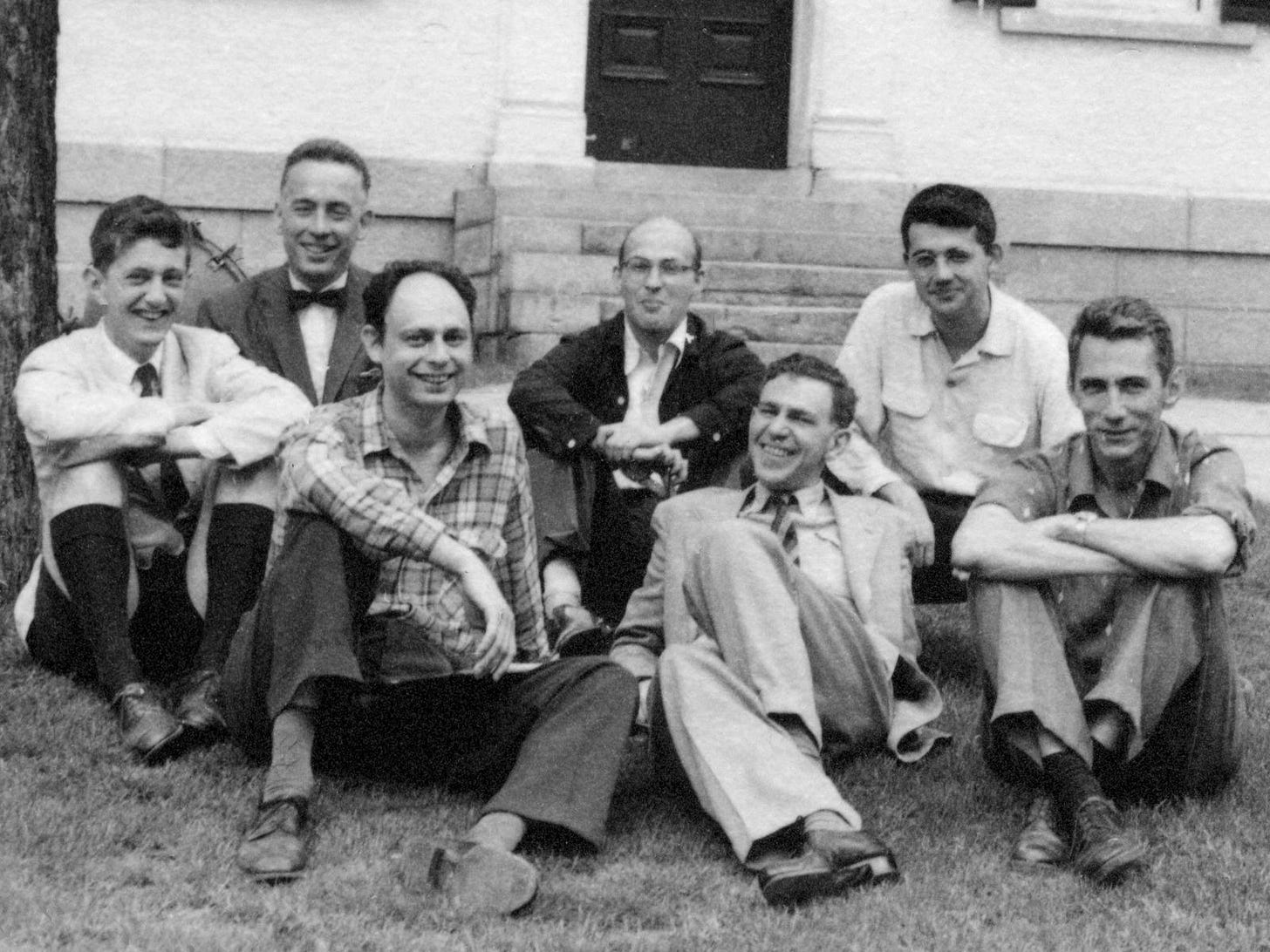 Close up of a black and white photo of seven smiling men, sitting on a lawn. Close up of a black and white photo of seven smiling men, sitting on a lawn.
