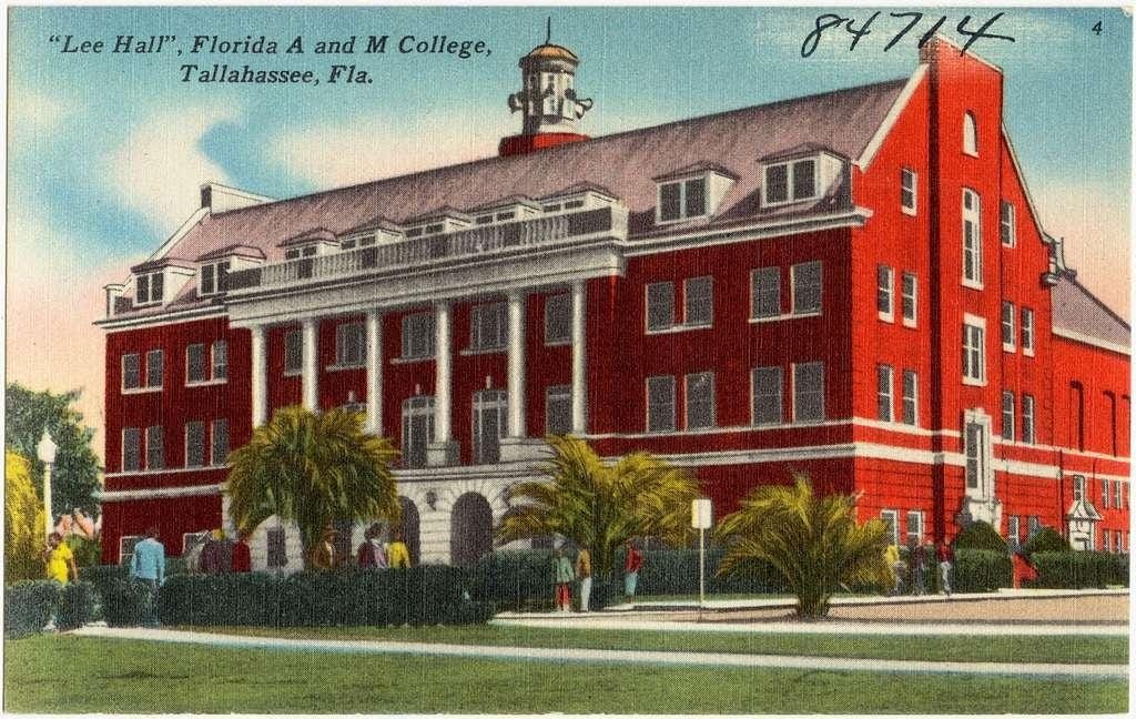 vintage postcard showing a red brick Colonial-style university building (much brighter red than in actual photos) with white columns. Several students can be seen outside, coming and going beneath low palm trees. Text on postcard, upper left: 'Lee Hall, Florida A & M College, Tallahassee, Fla.'  Handwritten number '84714' is in upper right corner. Image appears to be a tinted version of a B&W photo.