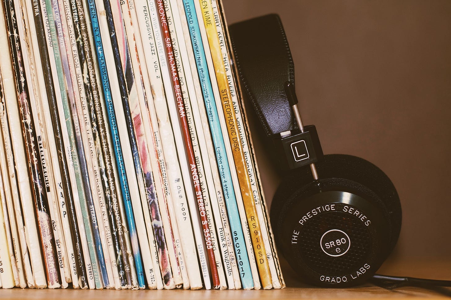 stack of records upright with a pair of black headphones next to it