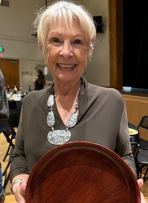 three women holding plaques they received