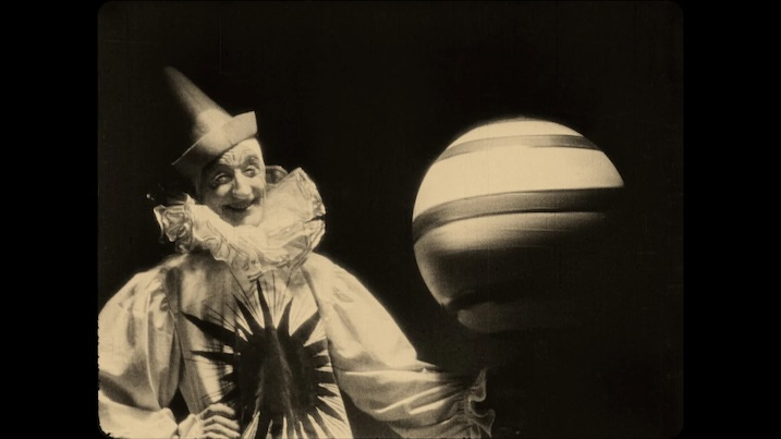 Chaney with globe: Lon Chaney in clown costume performing with a giant striped ball in He Who Gets Slapped (1924).