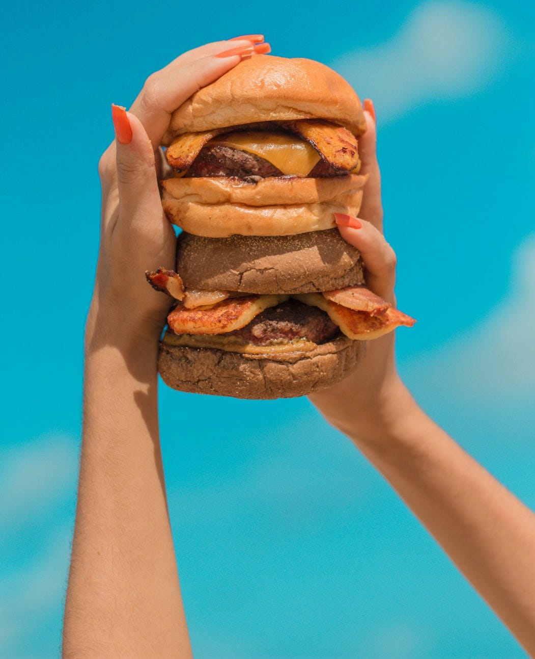 person holding burger with patty