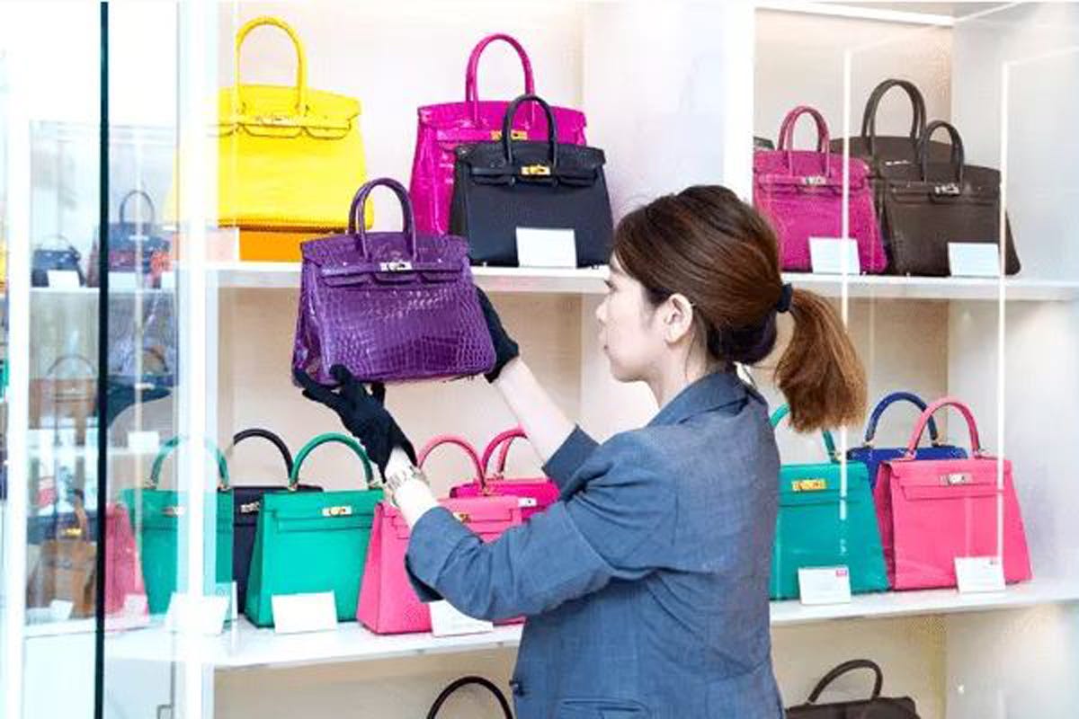 Una trabajadora coloca un bolso Hermès en una tienda Ginza Xiaoma. Una trabajadora coloca un bolso Hermès en una tienda Ginza Xiaoma.