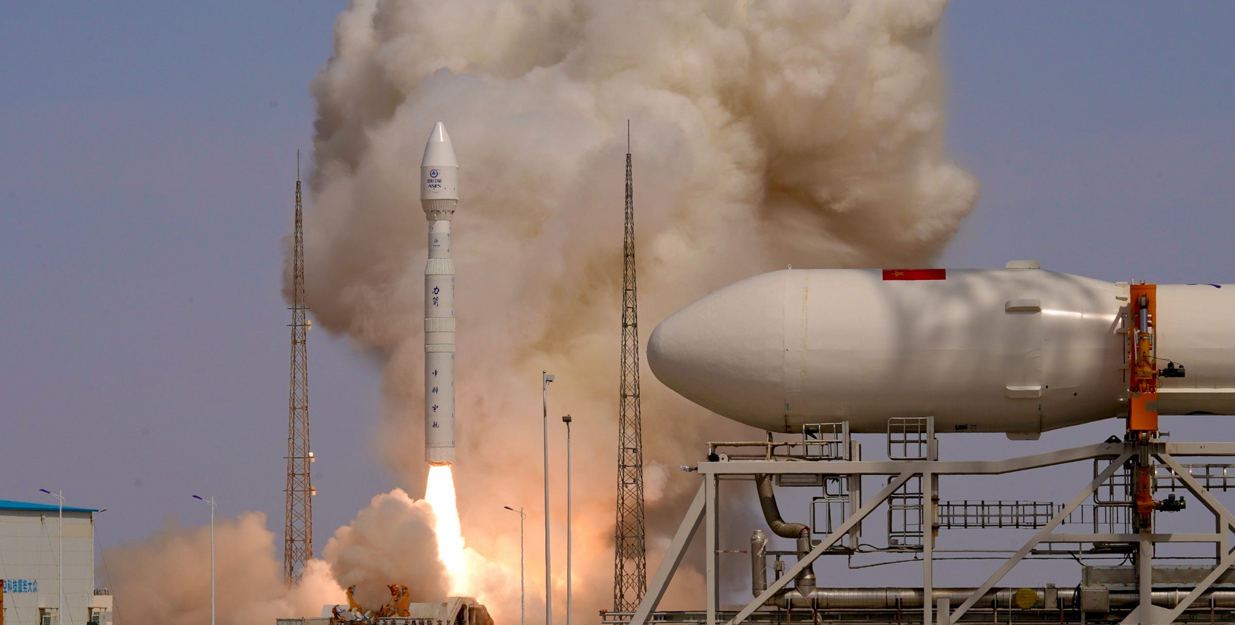 The Kinetica-1 Y10 vehicle lifts off from Launch Area 130 while a mockup of Kinetica-2 is sat between its launch hangar and Launch Area 140. The Kinetica-1 Y10 vehicle lifts off from Launch Area 130 while a mockup of Kinetica-2 is sat between its launch hangar and Launch Area 140.