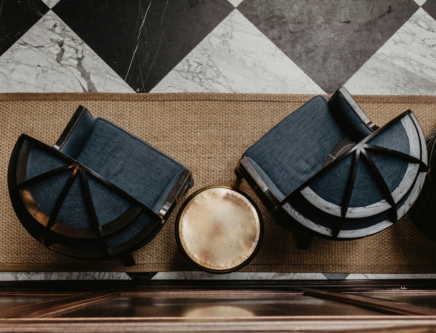 Overhead view of curved lounge seating arranged around circular table on woven flooring. Overhead view of curved lounge seating arranged around circular table on woven flooring.