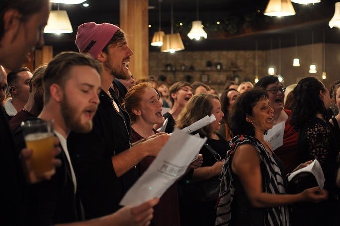 Singers with lyric sheets and beers in their hands. Singers with lyric sheets and beers in their hands.