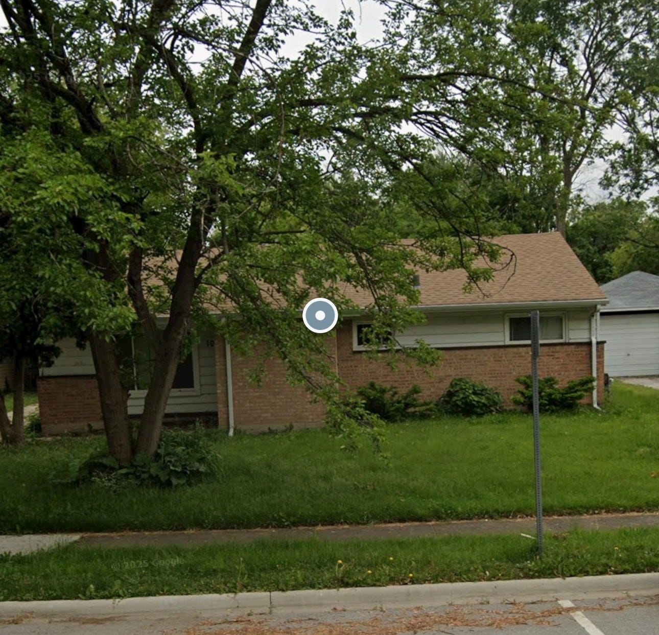 Small house with a tree in front of it.