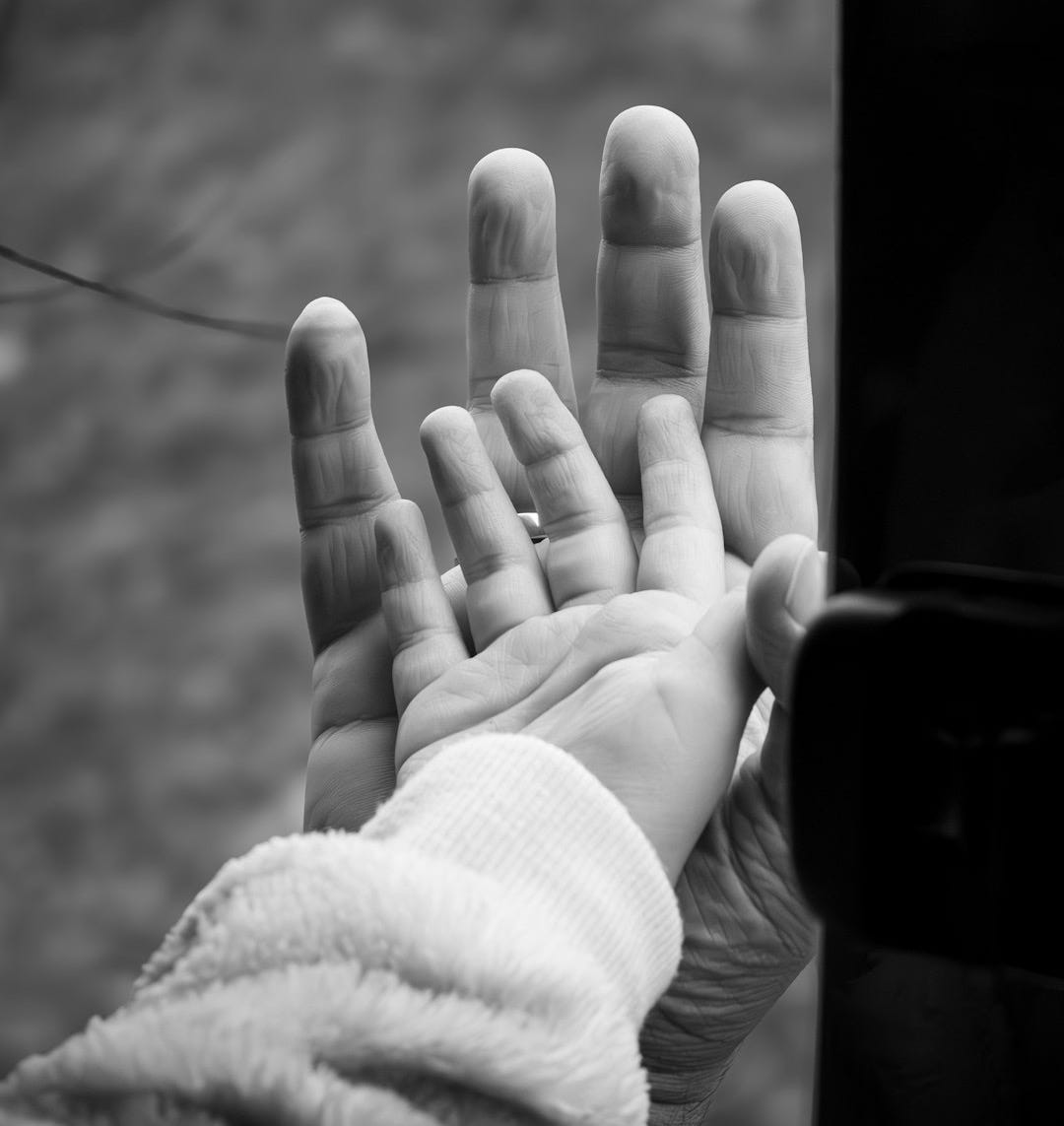 a black and white photo of a person holding their hand out
