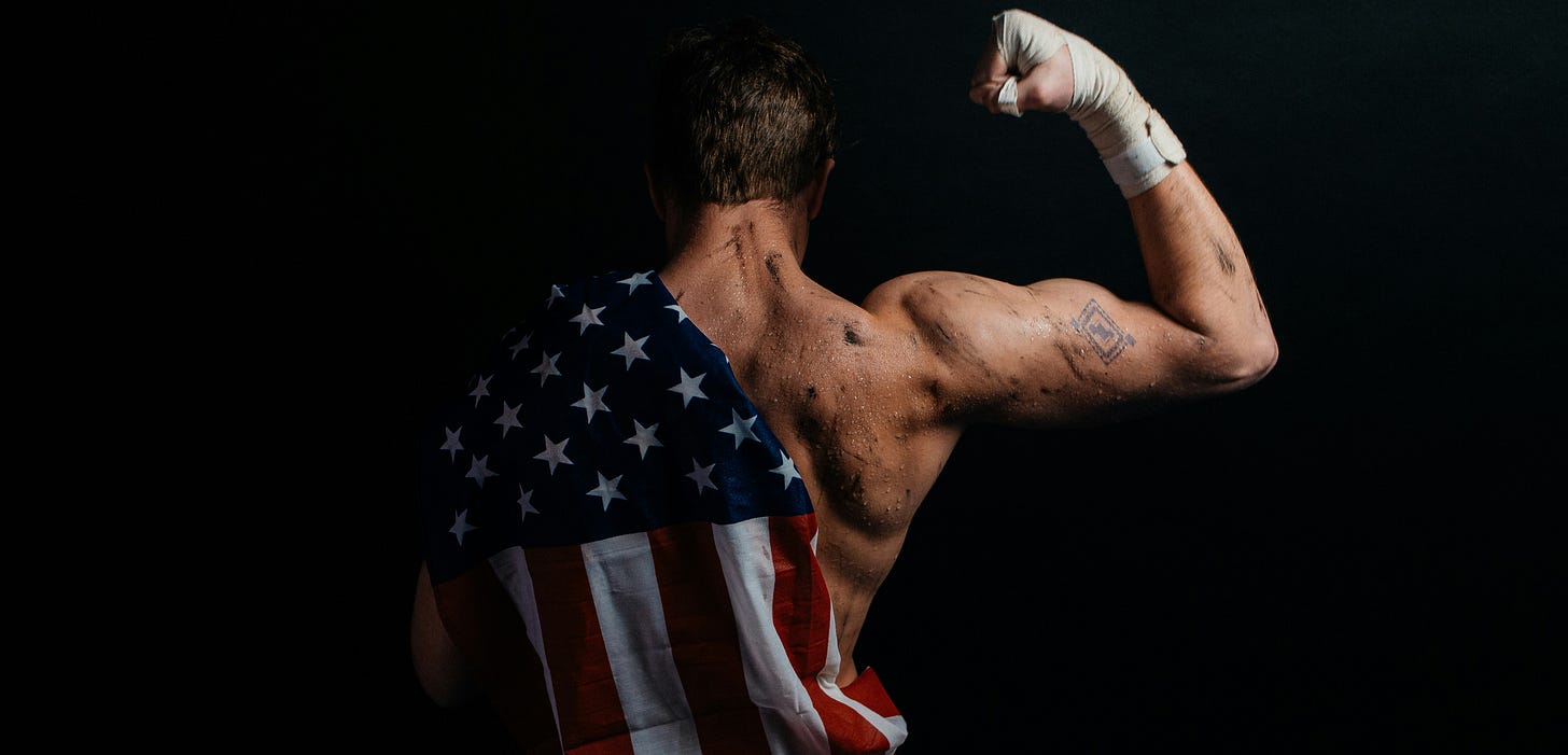 Shirtless male boxer flexes a taped fist with an American flag draped over his shoulder, illustrating macho patriotism, nationalism, masculinity, sports spectacle, and American political satire for the comedy essay Substack SOS: Satire or Something.