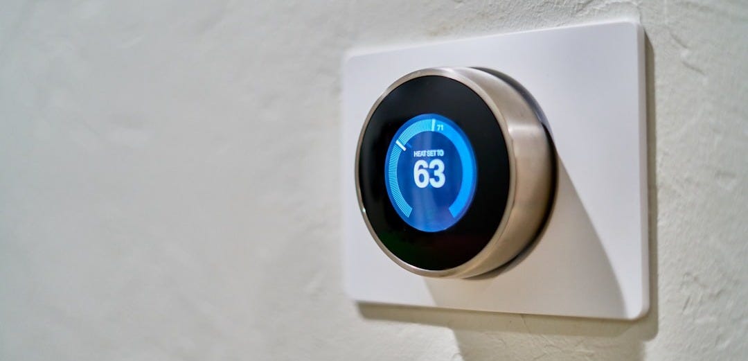gray Nest thermostat displaying at 63 gray Nest thermostat displaying at 63