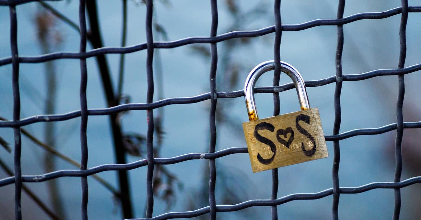Fence with a padlock labeled 'SOS,' with a heart-shaped 'O,' representing love.