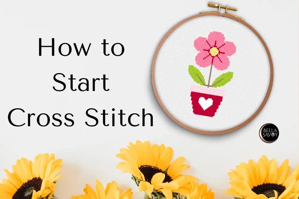 How to start cross stitch, with a wooden embroidery hoop displaying a colorful flower and heart design, surrounded by sunflowers.