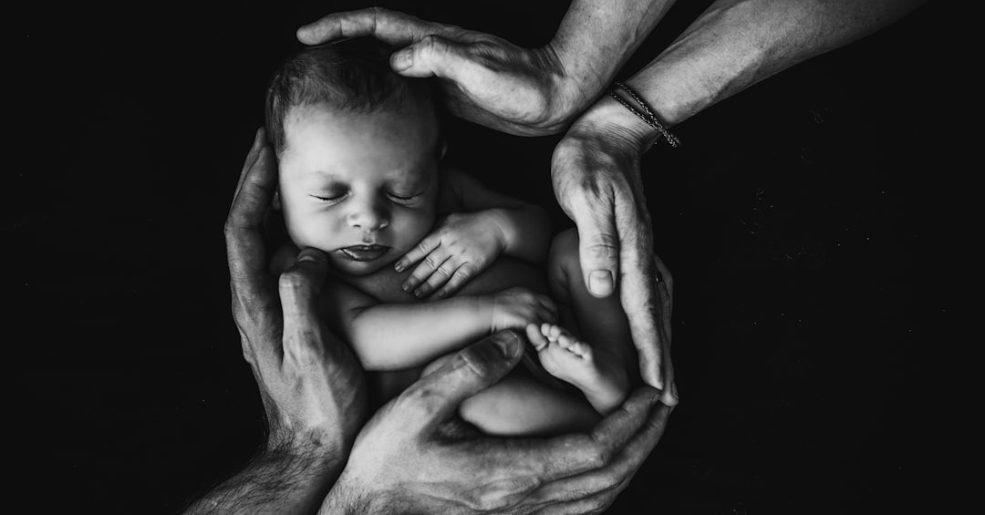 grayscale photo of woman hugging baby
