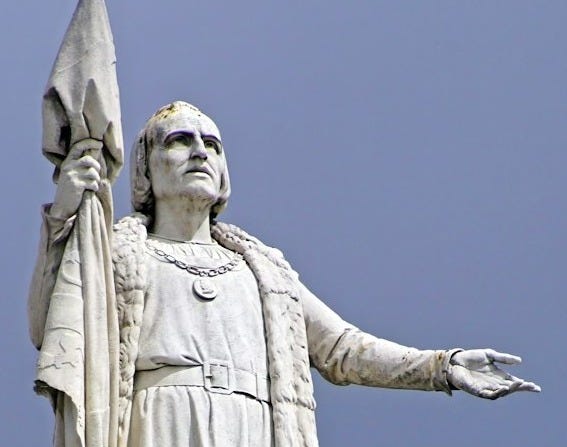 A statue of a man holding a flag on top of a building