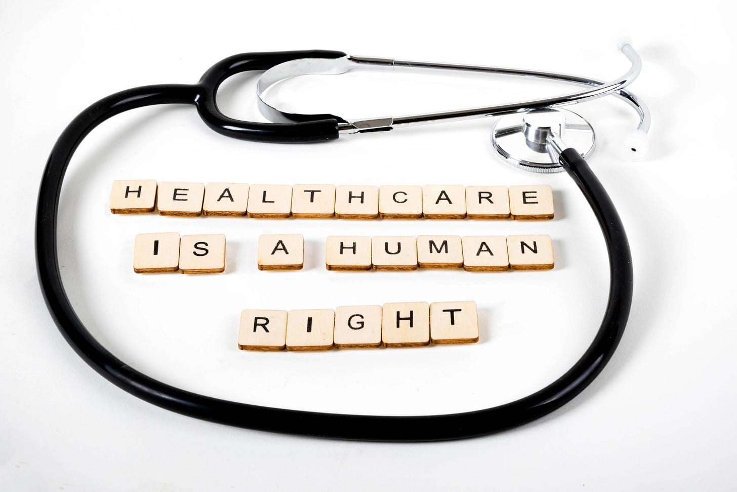 A stethoscope around scrabble letters spelling "Healthcare is a human right"
