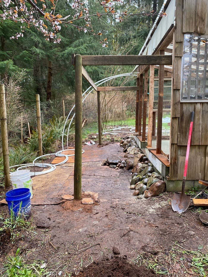 Cardboard is on the ground and two large posts are secured with white tubing attached to them.