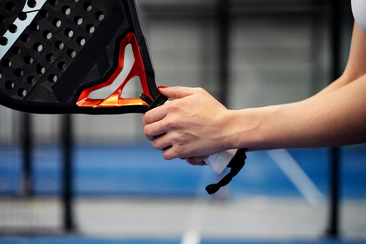 femme de 50 ans tenant une raquette de padel