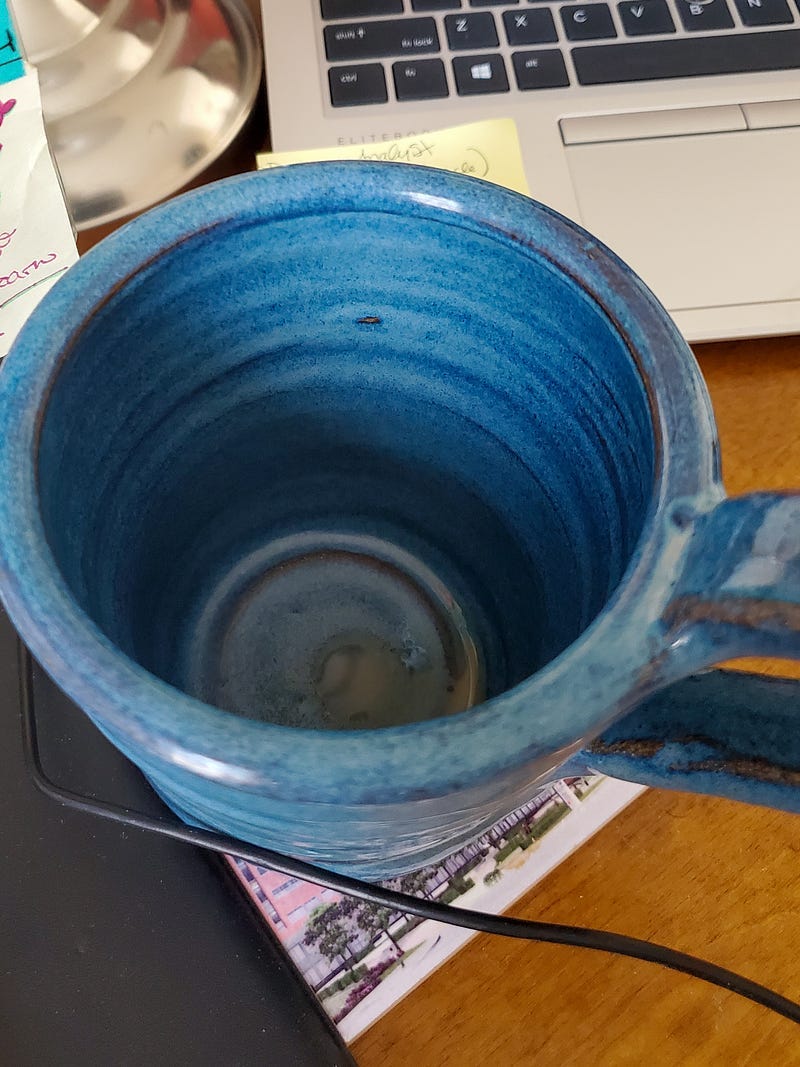 Blue handmade ceramic mug, empty, wishing it had coffee in it.