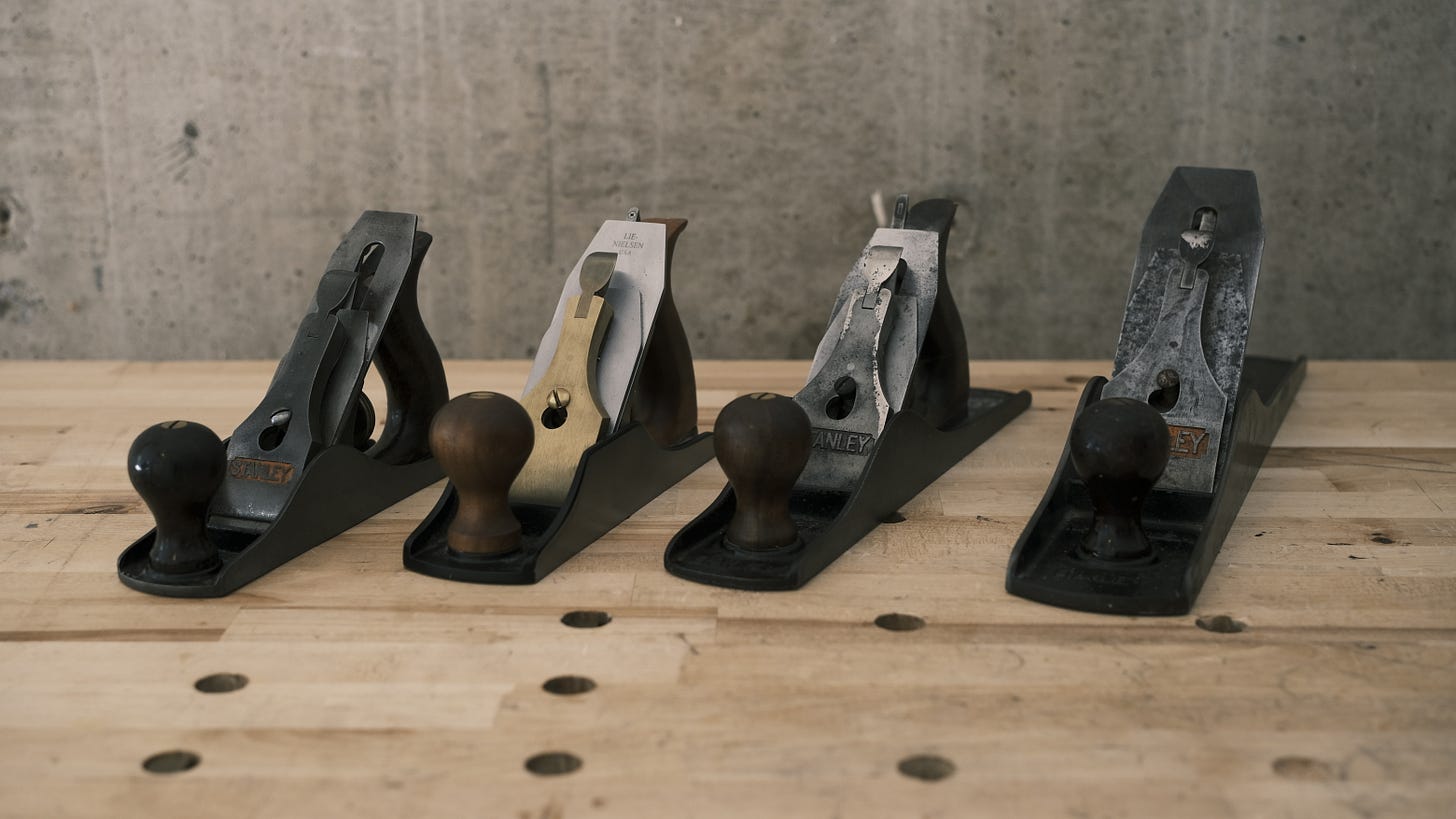 A selection of bench planes lined up in size order. Three vingage Stanleys and one moder Lie Nielsen. A selection of bench planes lined up in size order. Three vingage Stanleys and one moder Lie Nielsen.