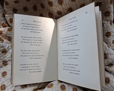 A spread of vintage books opened to reveal pressed four leaf clovers