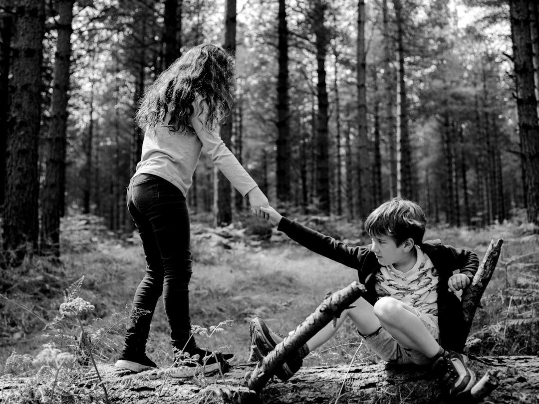boy and girl playing on three tree log boy and girl playing on three tree log