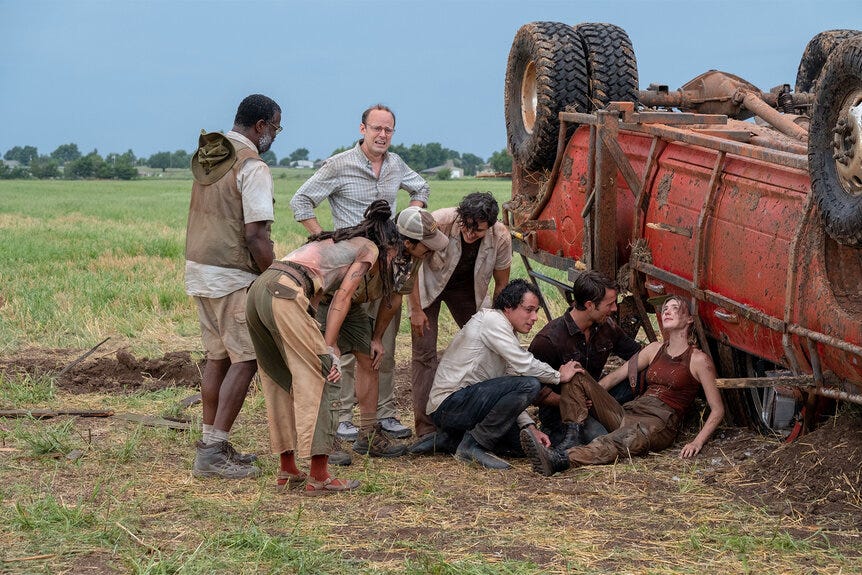 A screenshot from the 2024 film Twisters. Daisy Edgar-Jones, bloodied and disheveled but alive, leans against the wreckage of an overturned truck and looks hopefully at the sky. Glen Powell kneels next to her with his hand on her back. Anthony Ramos is also crouched next to her with his hand on her knee. Several other characters are gathered around them, relieved. In the background, the grassy Oklahoma field stretches toward a clear sky. A screenshot from the 2024 film Twisters. Daisy Edgar-Jones, bloodied and disheveled but alive, leans against the wreckage of an overturned truck and looks hopefully at the sky. Glen Powell kneels next to her with his hand on her back. Anthony Ramos is also crouched next to her with his hand on her knee. Several other characters are gathered around them, relieved. In the background, the grassy Oklahoma field stretches toward a clear sky.