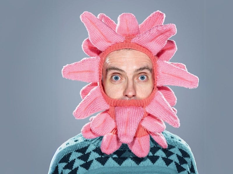 man with a knitted hat with many pink tongues
