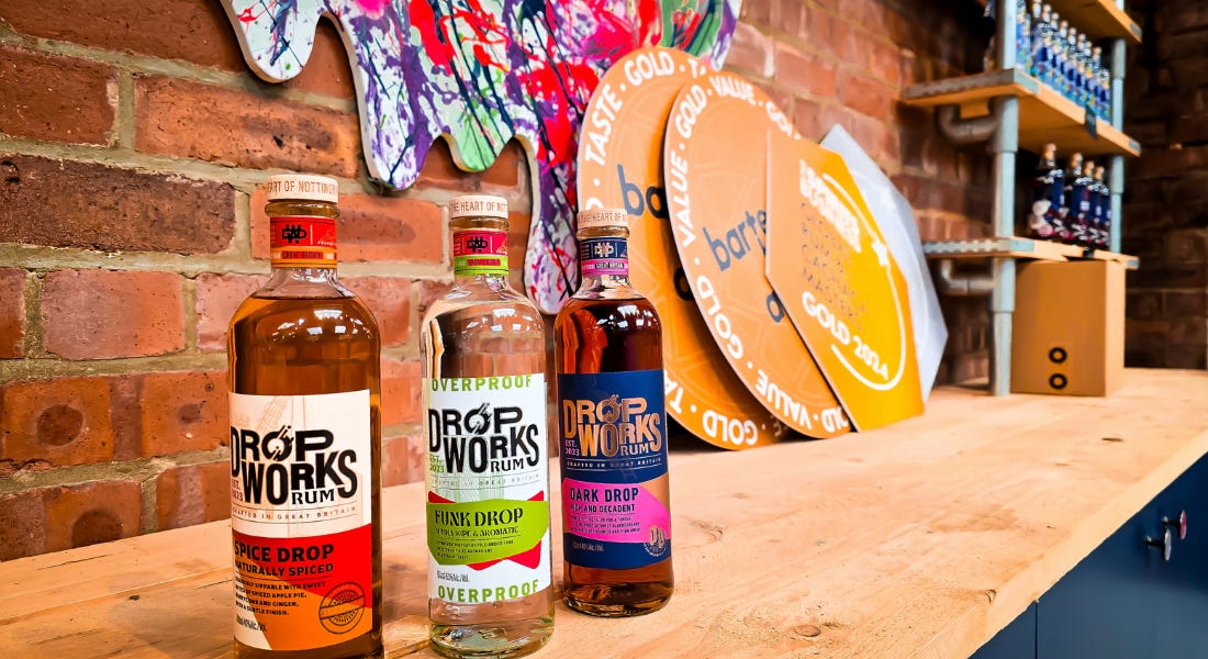 Three rum bottles in a row on top of a wooden counter with brick walls behind them Three rum bottles in a row on top of a wooden counter with brick walls behind them