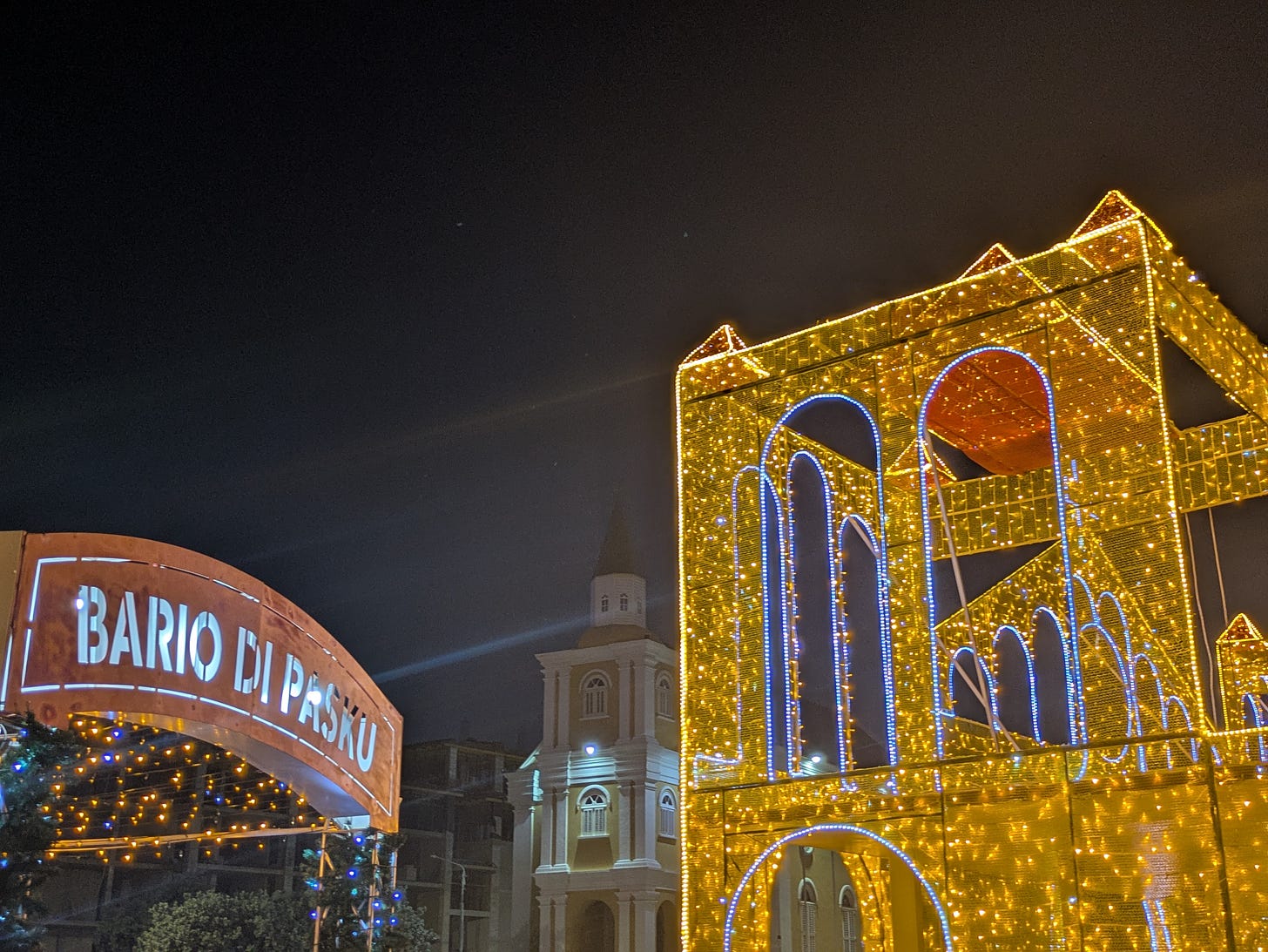 Christmas lights up in downtown Willemstad, Curaçao. A sign that says Bario di Pasku, which translates to Christmas neighborhood. Christmas lights up in downtown Willemstad, Curaçao. A sign that says Bario di Pasku, which translates to Christmas neighborhood.